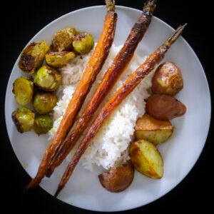 Roasted carrots, brussels sprouts, and potatoes over rice