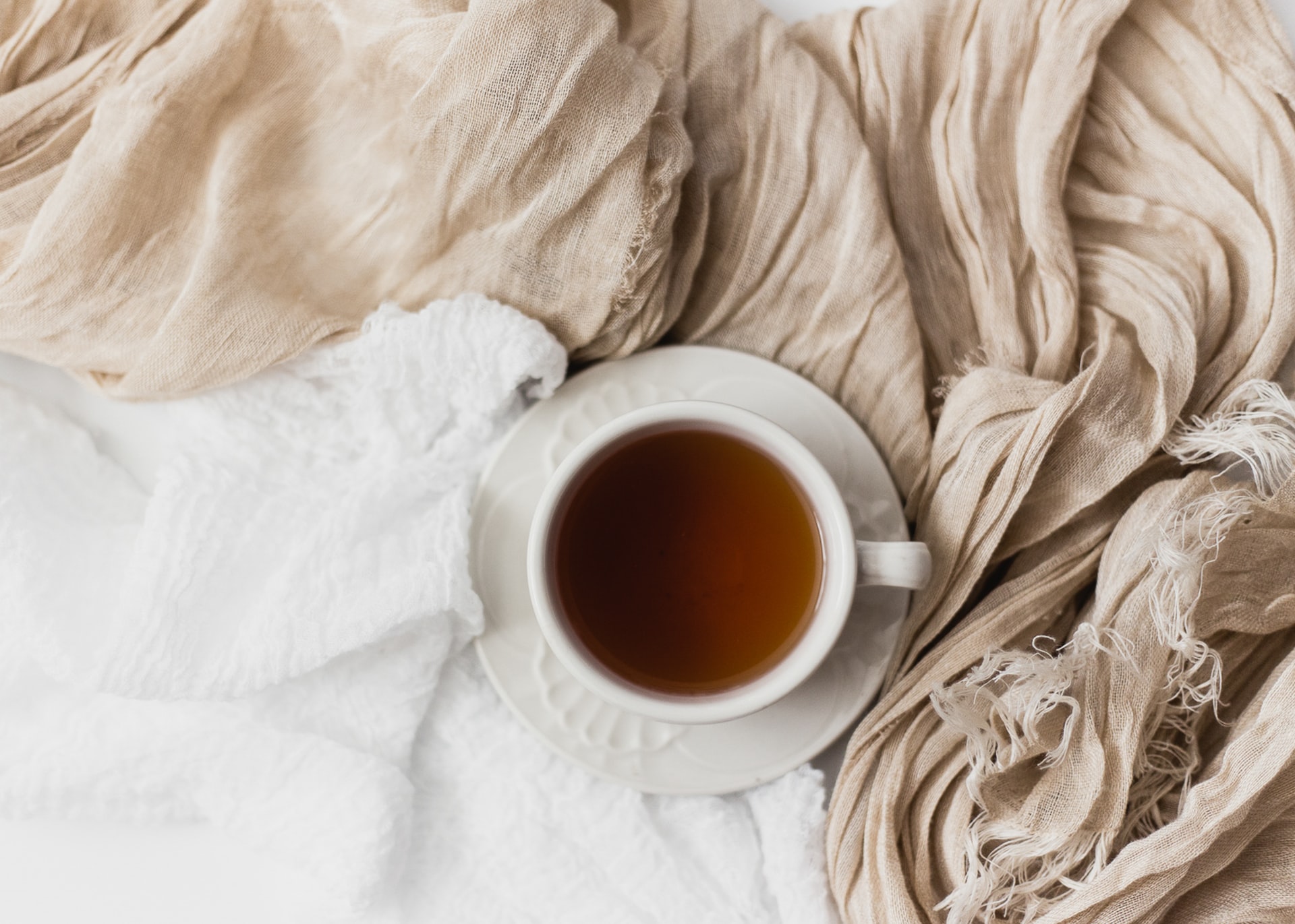 Flat shot of a tea cup and linens. Photo by Sixteen Miles Out on Unsplash